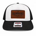 White and black trucker hat with brown leather patch and label on a white background