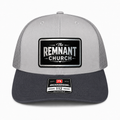 A light gray and dark gray trucker cap with a black and silver 'The Remnant Church' patch on the front and a Richardson 112 sticker on the brim, shown against a plain white background.