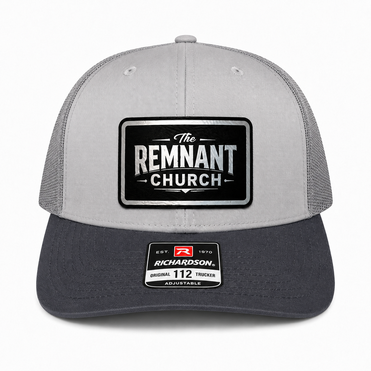 A light gray and dark gray trucker cap with a black and silver 'The Remnant Church' patch on the front and a Richardson 112 sticker on the brim, shown against a plain white background.